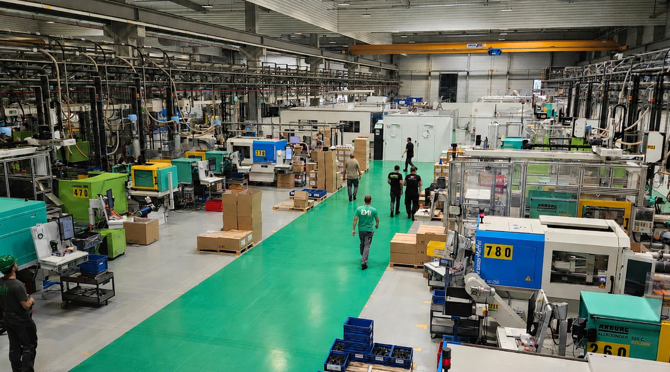 photo d'une allée de production avec des presses et des salariés marchant dans l'allée centrale